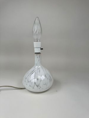 une lampe en verre posée sur une table