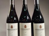 three bottles of wine sitting on top of a table next to each other