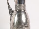 a silver pitcher that is sitting on a table