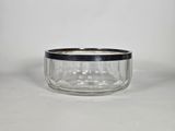 a clear glass jar with a black lid on a white surface