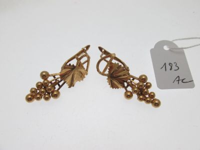 une paire de boucles d'oreilles en or ornées de feuilles et de baies