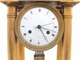 a gold clock with roman numerals on it