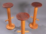 three wooden stools sitting next to each other on top of a table