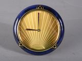 une horloge bleue et dorée posée sur une surface blanche