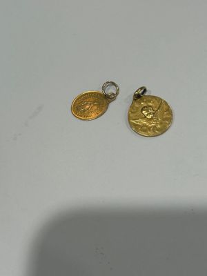 a close up of two gold coins on a white surface