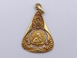 an image of a gold plated pendant with an image of a woman on it
