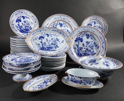 Des assiettes et des bols en porcelaine bleue et blanche sont disposés sur une surface noire