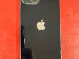 Un iPhone est posé sur une surface rouge, à côté d'un mur rouge.