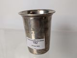 a silver cup sitting on a table with a label on it