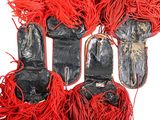 several pairs of black and red shoes with red fringes on a white surface