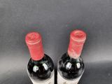 two bottles of wine sitting on top of a table next to each other