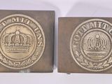two antique brass belt buckles with a crown on them