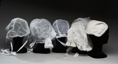 quatre têtes de mannequins, coiffées de voiles et de chapeaux, alignées les unes à côté des autres