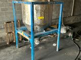 a metal tank sitting on a blue stand in a building