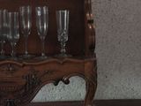 a wooden shelf with wine glasses on top of it