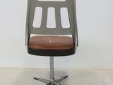 a chair with a brown seat on a metal stand