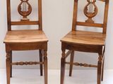 pair of wooden chairs with a harp on the back of them