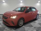 a red car is parked in a room with a checkered floor