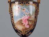 un grand vase décoré d'une peinture, posé sur une table