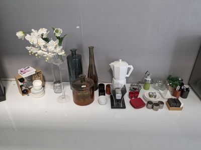 une table blanche sur laquelle sont disposées des bouteilles et des vases remplis de produits de beauté