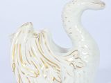 a white swan shaped vase with a gold decoration on it