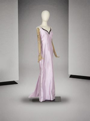 une photo d'un mannequin portant une robe violette dans une pièce