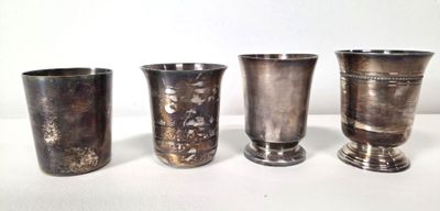 four silver vases sitting on a table next to each other