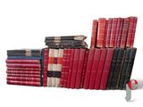 several old books stacked on top of each other on a white surface