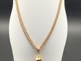a gold necklace with a red bead and a gold chain
