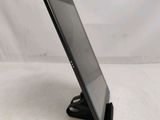 the tablet is sitting on a stand on a white surface