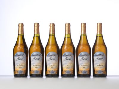 four bottles of wine are lined up on a table