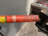 a red fire extinguisor attached to a metal pipe