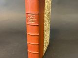 an orange book sitting on top of a table next to a gray wall