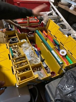 un homme qui tient une boîte à outils remplie d'outils