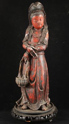 an old statue of a woman with a basket on her shoulder