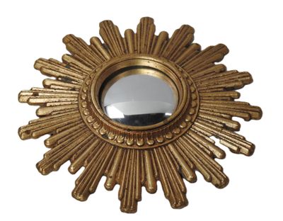 un miroir doré en forme de soleil rayonnant sur fond blanc