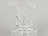 figurine en verre transparent représentant un snowboardeur, posée sur un socle transparent