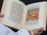 a person holding an open book with a picture on it