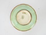 a green plate with a gold rim on a white table
