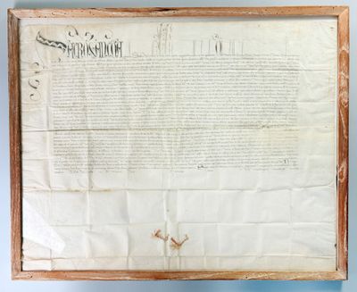an old document with writing on it hanging on a wall