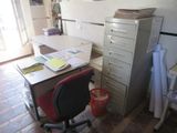 un bureau avec un classeur et une chaise dans la pièce