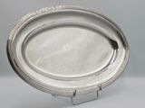 an image of a silver plate sitting on top of a metal stand