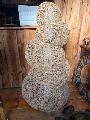 a snowman made out of rope on a wooden floor