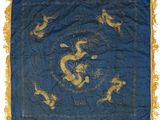 a blue and gold silk table cloth with a dragon design on it