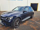 une Mercedes GLE bleue garée devant un immeuble
