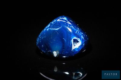 gros plan d'une pierre bleue sur une surface noire