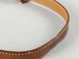 a brown leather dog collar with white stitching on it