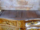 a wooden chest of drawers with gold decorations on it