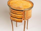 a small wooden table with three drawers on it