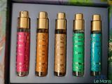 four bottles of perfume are lined up in a box